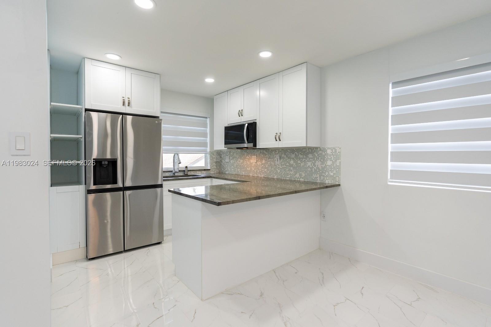 13270 Southwest 103rd Terrace, Unit 2 Miami, FL 33186 - Photo 13 of 41 a kitchen with stainless steel appliances granite countertop a refrigerator and a sink