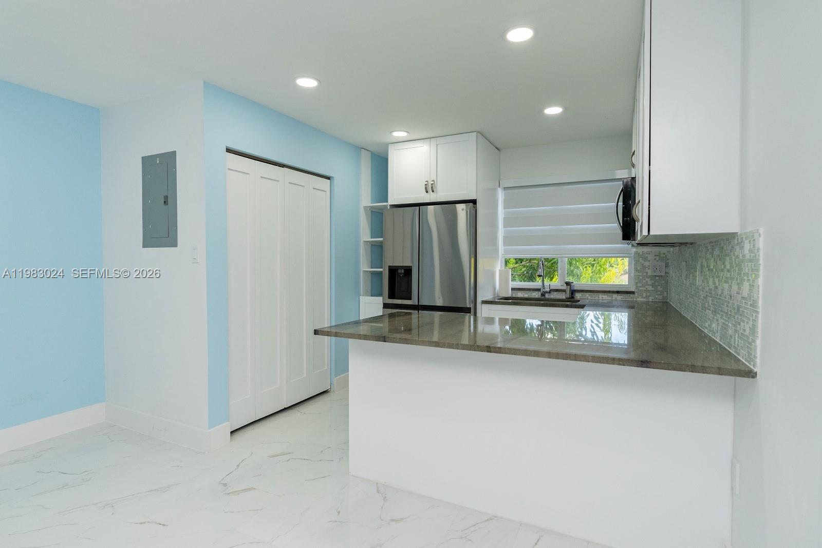 13270 Southwest 103rd Terrace, Unit 2 Miami, FL 33186 - Photo 15 of 41 a kitchen with stainless steel appliances granite countertop a sink and a refrigerator