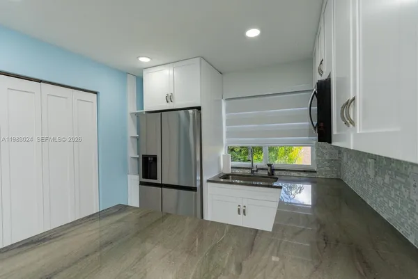 a kitchen with stainless steel appliances a refrigerator and a stove top oven