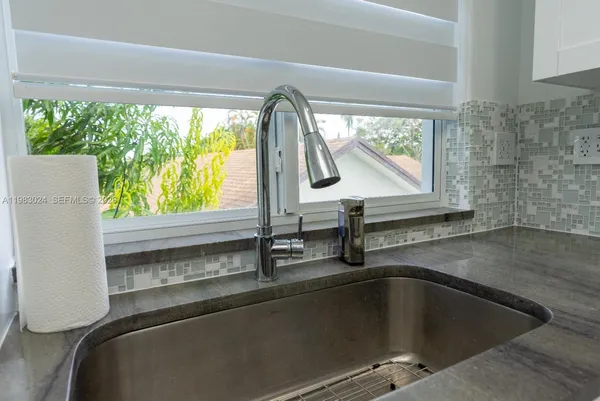 a view of a kitchen with a sink and stainless steel appliances