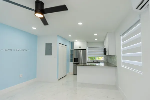 a view of kitchen with refrigerator and window