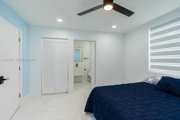 a bedroom with a bed and a ceiling fan