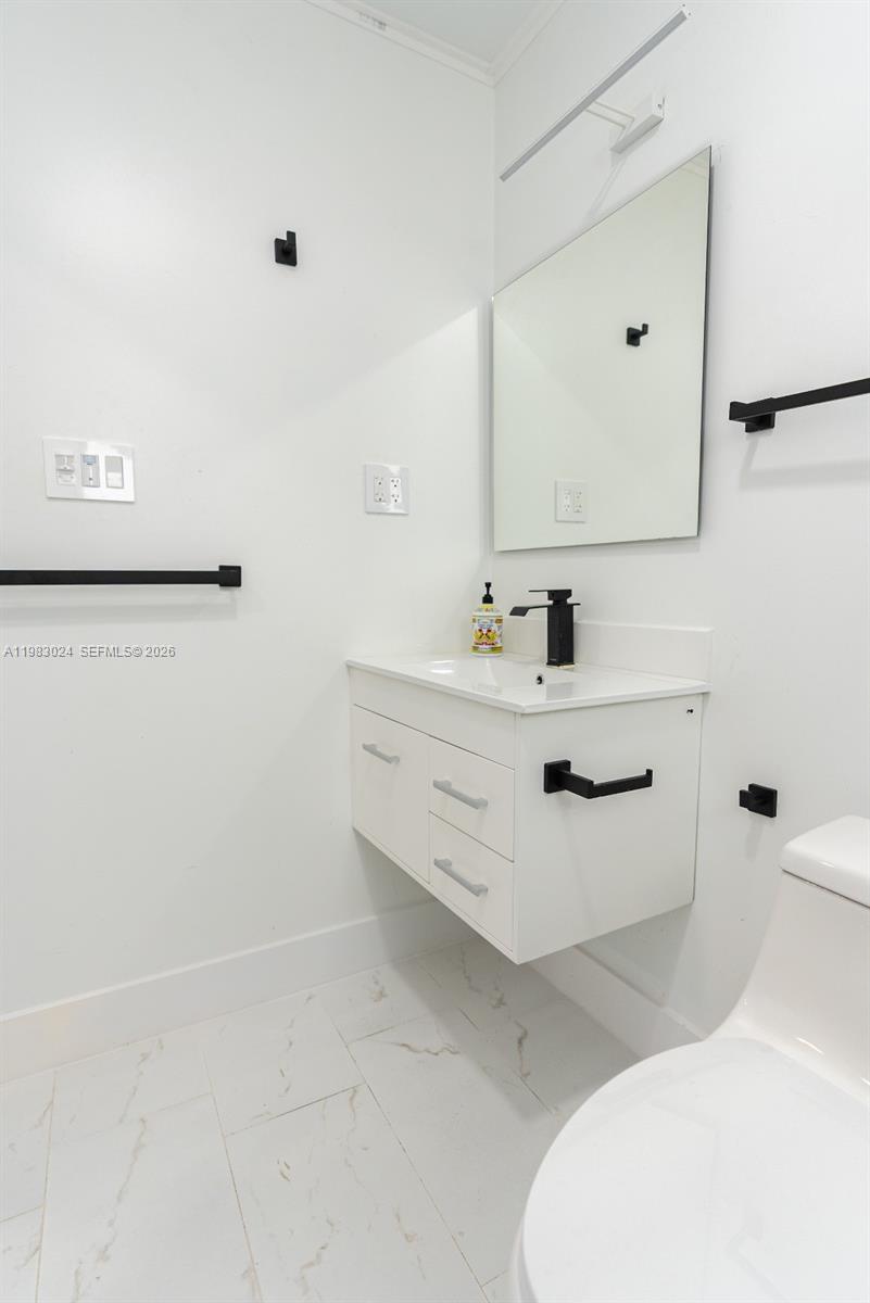 13270 Southwest 103rd Terrace, Unit 2 Miami, FL 33186 - Photo 29 of 41 a bathroom with a sink toilet and mirror