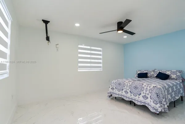 a bedroom with a bed and a ceiling fan