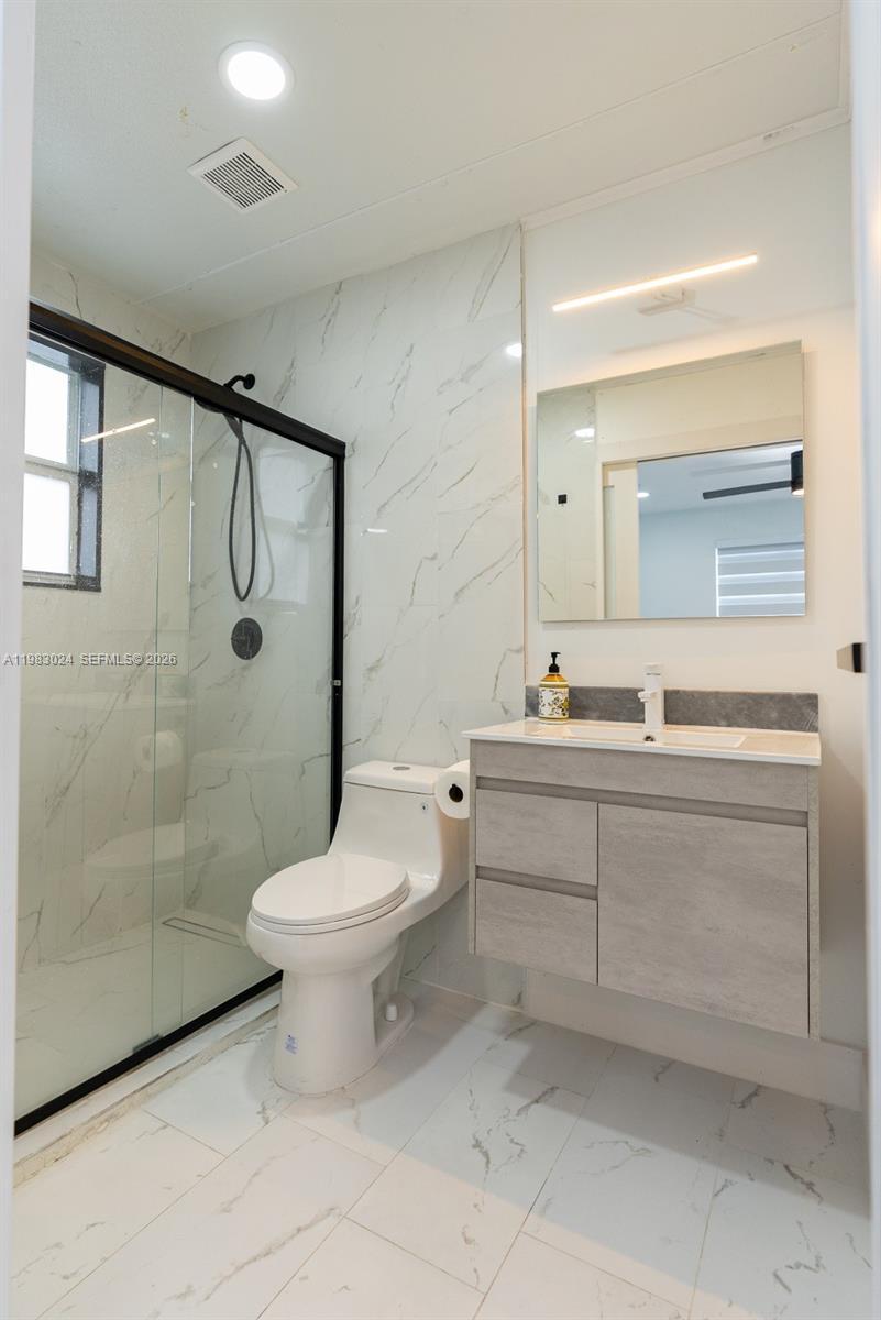 13270 Southwest 103rd Terrace, Unit 2 Miami, FL 33186 - Photo 39 of 41 a bathroom with a double vanity sink toilet and shower
