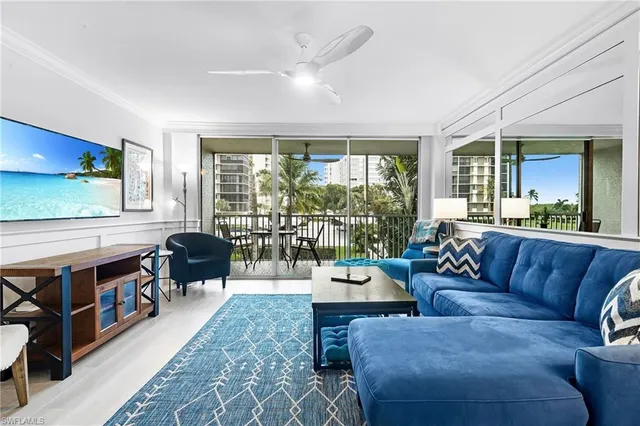 a living room with furniture and a floor to ceiling window