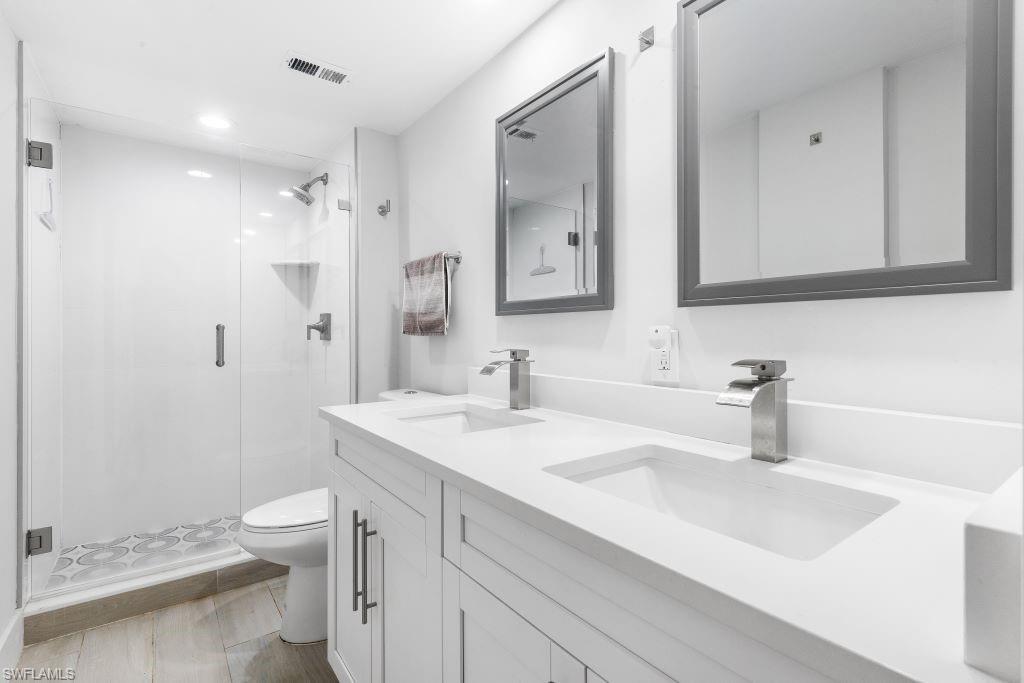 5 Bluebill Avenue, Unit 209 Naples, FL 34108 - Photo 14 of 32 a bathroom with a sink a toilet and a large mirror