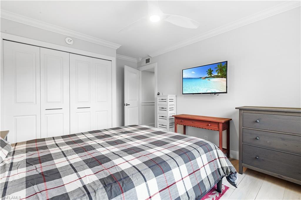 5 Bluebill Avenue, Unit 209 Naples, FL 34108 - Photo 17 of 32 a bedroom with a bed and a painting on the wall