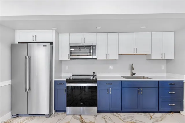 a kitchen with a sink a refrigerator and cabinets