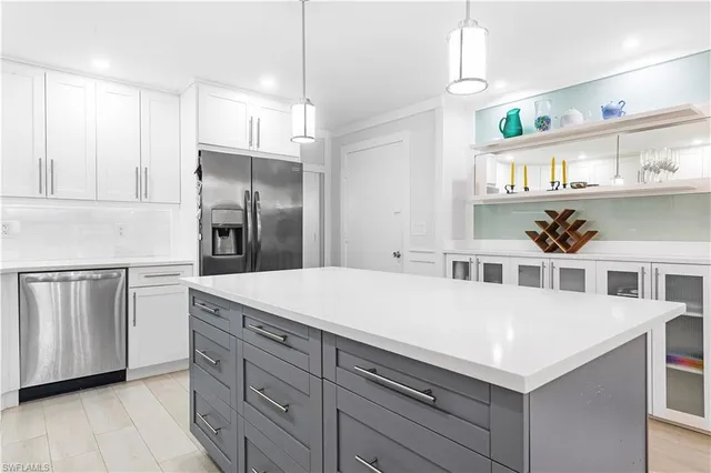 a kitchen with a refrigerator and white cabinets