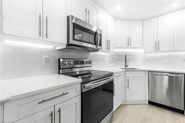 a kitchen with cabinets stainless steel appliances and a sink
