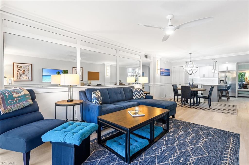 5 Bluebill Avenue, Unit 209 Naples, FL 34108 - Photo 10 of 32 a living room with furniture a table and kitchen view