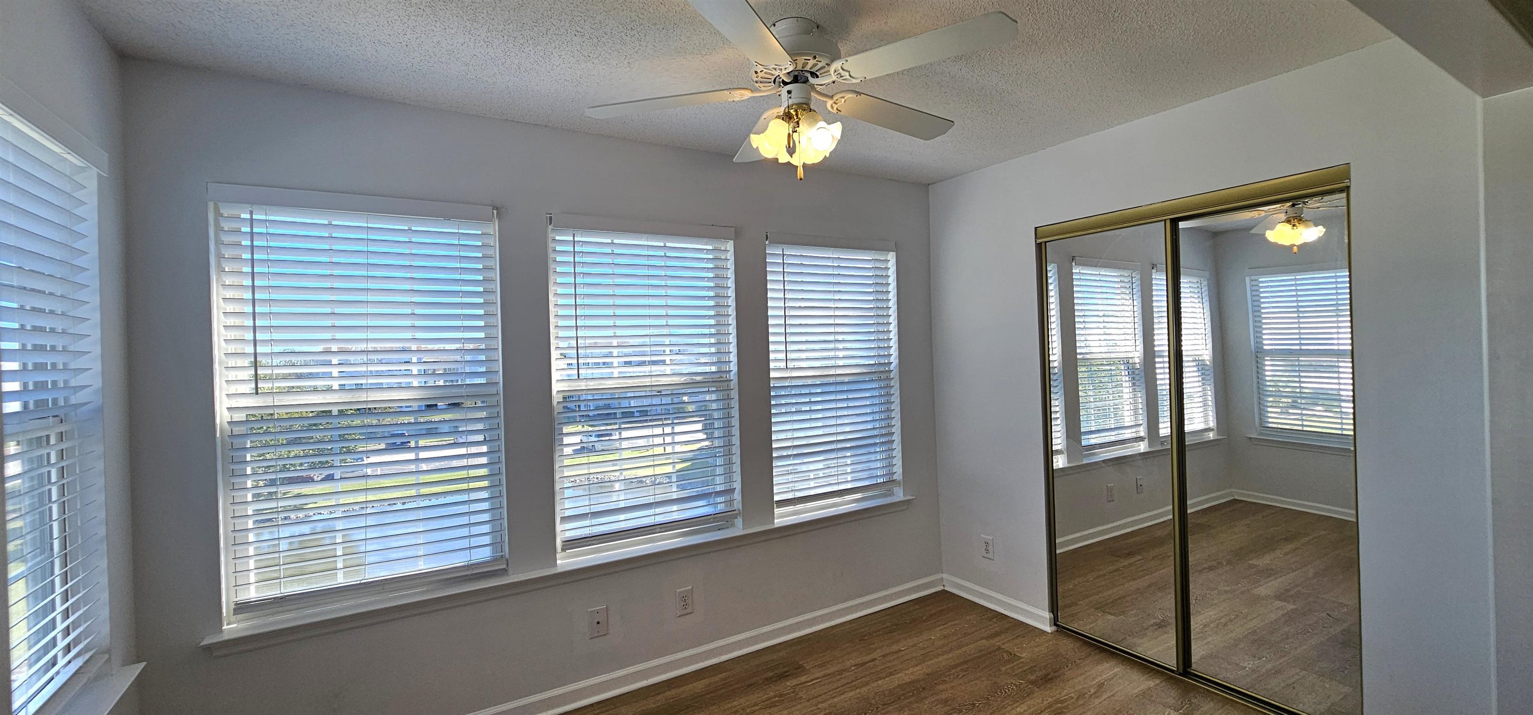 2273 Huntingdon Drive, Unit J Myrtle Beach, SC 29575 - Photo 15 of 24 Unfurnished bedroom featuring ceiling fan, a textured ceiling, dark wood-type flooring, and a closet