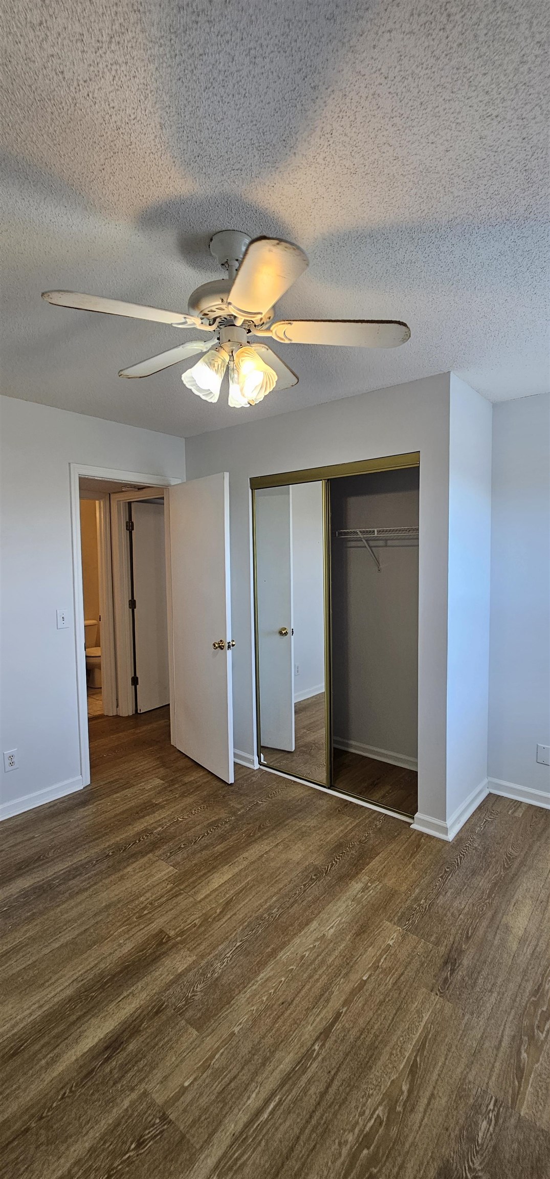 2273 Huntingdon Drive, Unit J Myrtle Beach, SC 29575 - Photo 24 of 24 Unfurnished bedroom featuring a closet, ceiling fan, dark wood-type flooring, and a textured ceiling