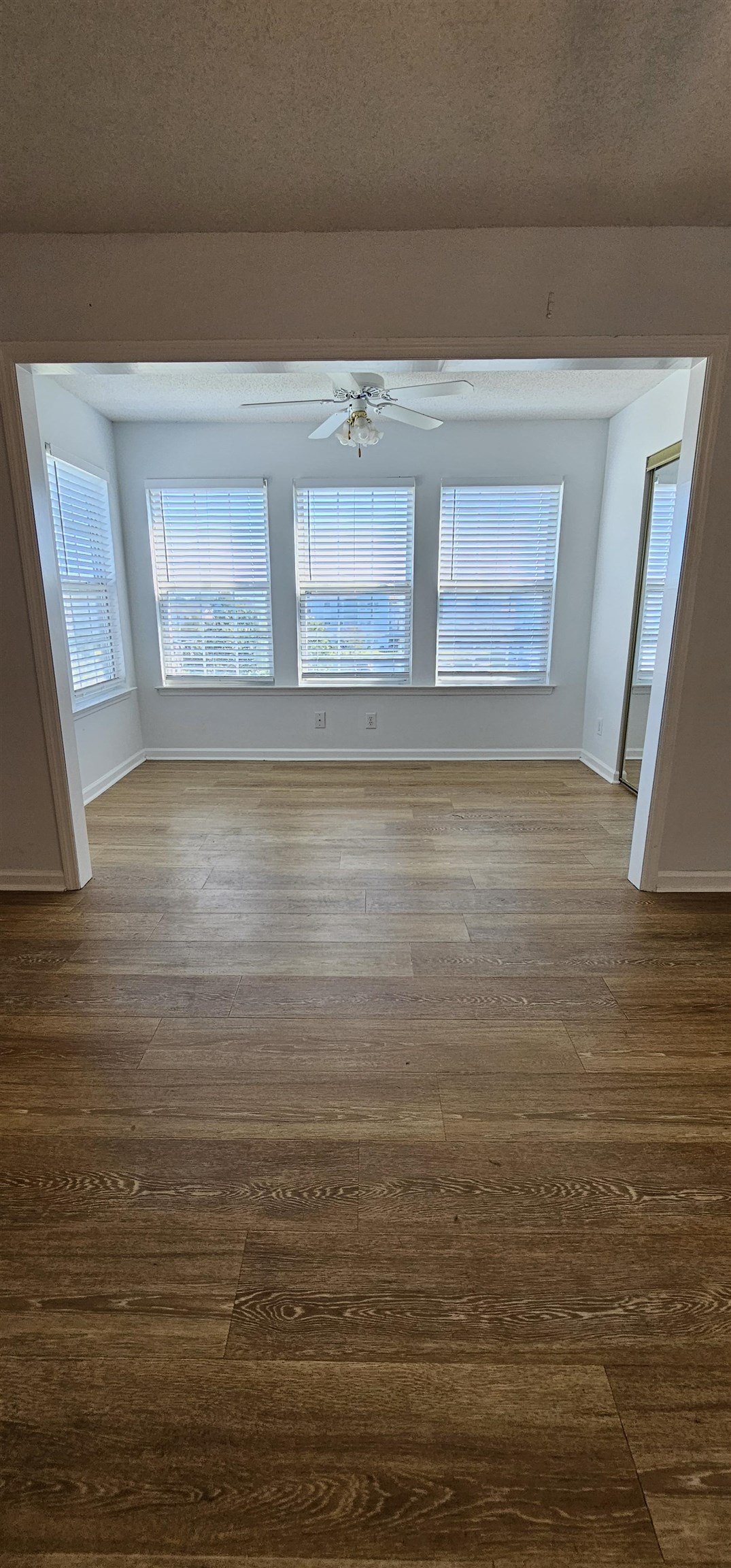 2273 Huntingdon Drive, Unit J Myrtle Beach, SC 29575 - Photo 7 of 24 Spare room featuring plenty of natural light, hardwood / wood-style flooring, and a textured ceiling