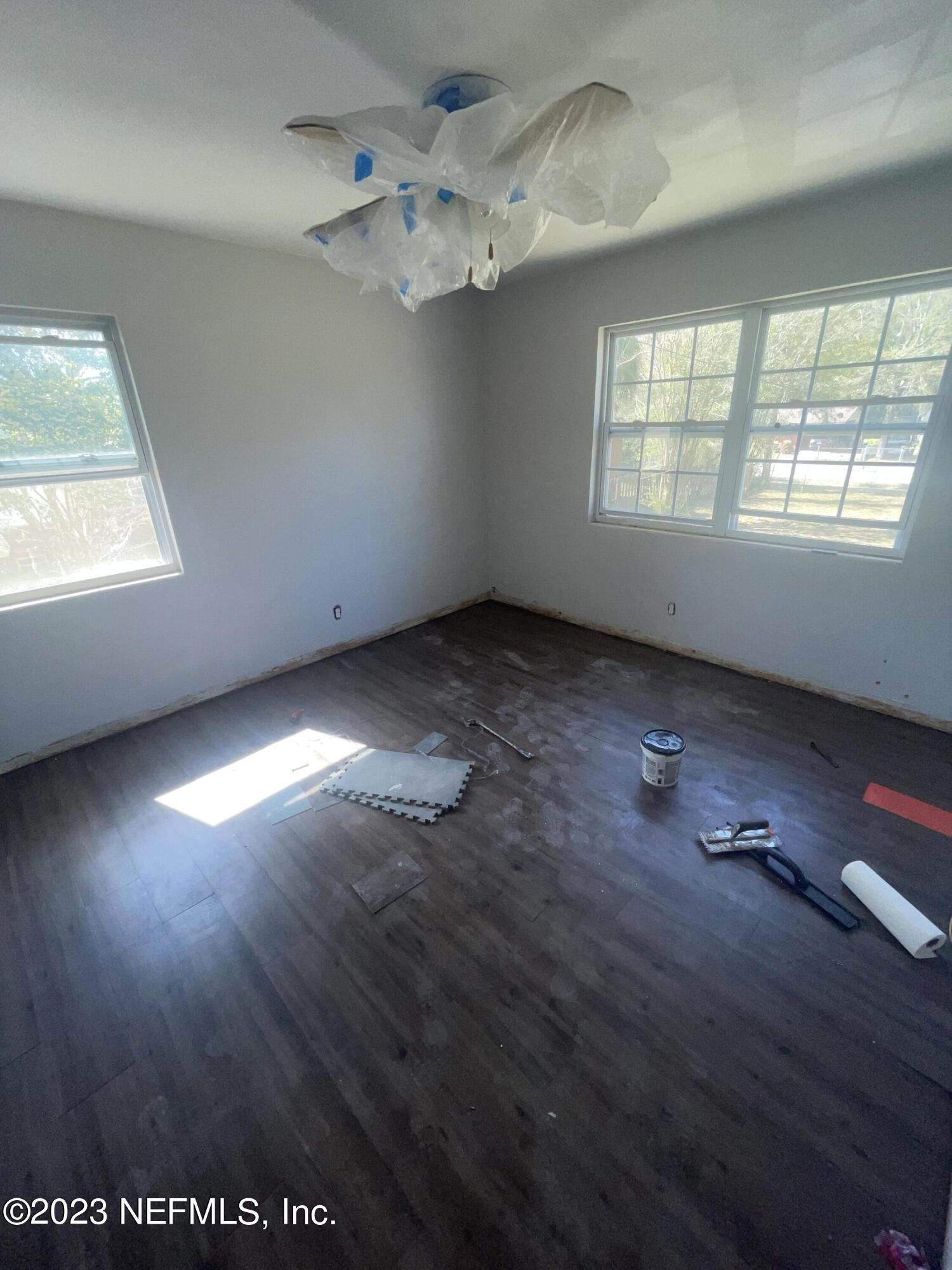 6519 Champlain Road Jacksonville, FL 32208 - Photo 2 of 4 an empty room with wooden floor and windows