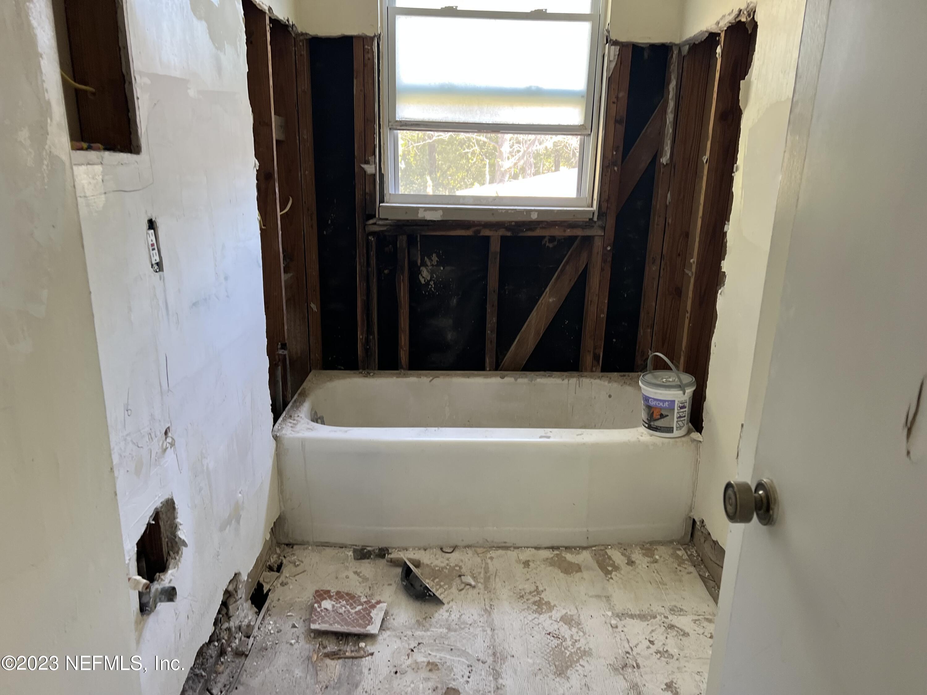 6519 Champlain Road Jacksonville, FL 32208 - Photo 3 of 4 a bathroom with a bathtub and a window