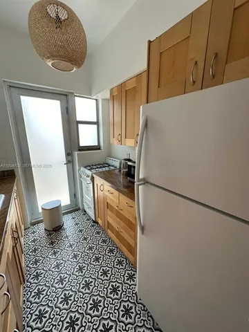 a kitchen with a refrigerator a stove a sink and a window