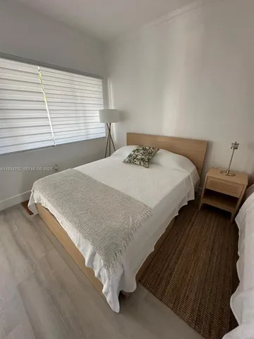 a bed sitting in a bedroom next to a window
