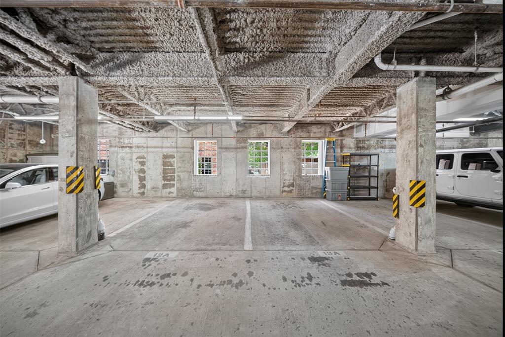 5015 Meridian Lane, Unit 2102 Addison, TX 75001 - Photo 33 of 36 Concrete parking space with exposed concrete ceiling and support columns