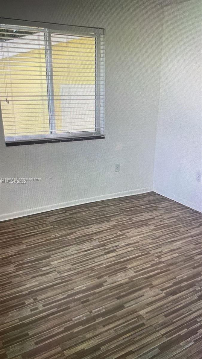 7637 Northwest 3rd Avenue, Unit 1 Miami, FL 33150 - Photo 16 of 20 a view of an empty room with wooden floor and a window