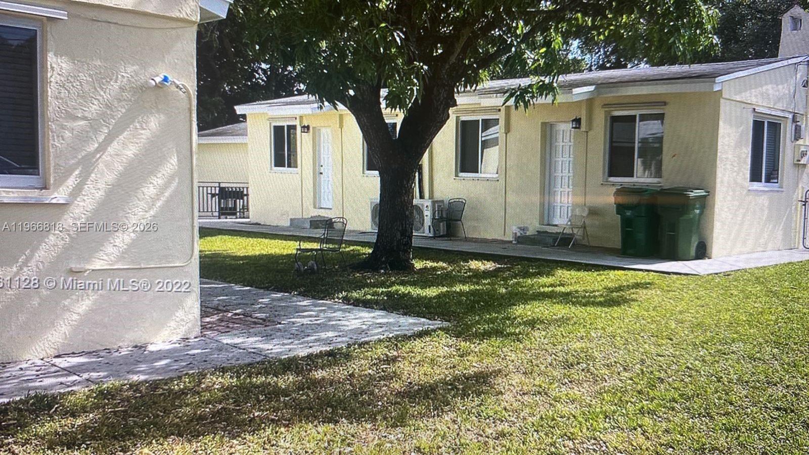 7637 Northwest 3rd Avenue, Unit 1 Miami, FL 33150 - Photo 2 of 20 a view of a white house with large windows and a yard
