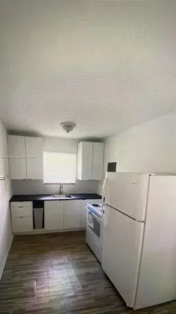a kitchen with wooden cabinets and white appliances