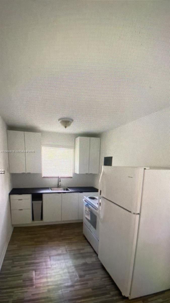 7637 Northwest 3rd Avenue, Unit 1 Miami, FL 33150 - Photo 5 of 20 a kitchen with wooden cabinets and white appliances