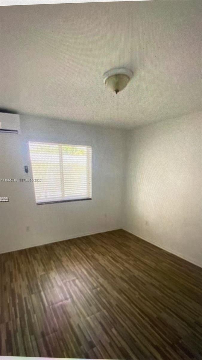 7637 Northwest 3rd Avenue, Unit 1 Miami, FL 33150 - Photo 7 of 20 an empty room with wooden floor and windows