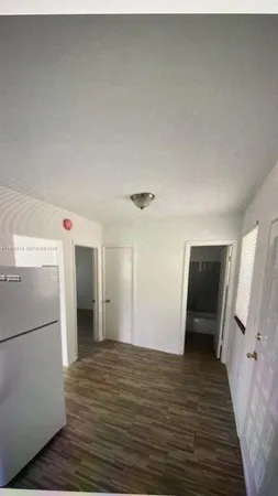 a view of a refrigerator in kitchen and wooden floor