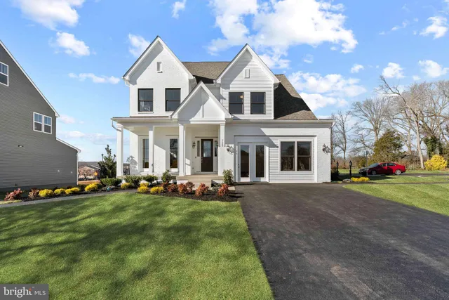 a front view of a house with a yard and trees