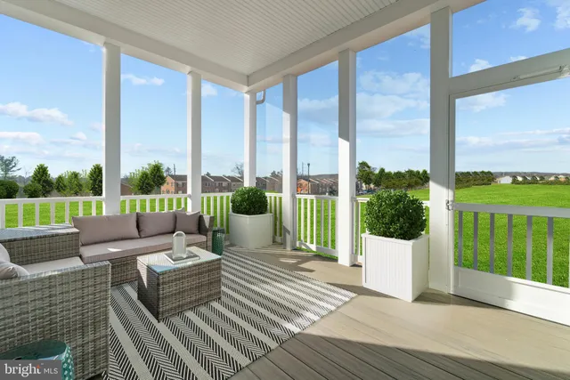 a view of a patio with couches potted plants and wooden floor