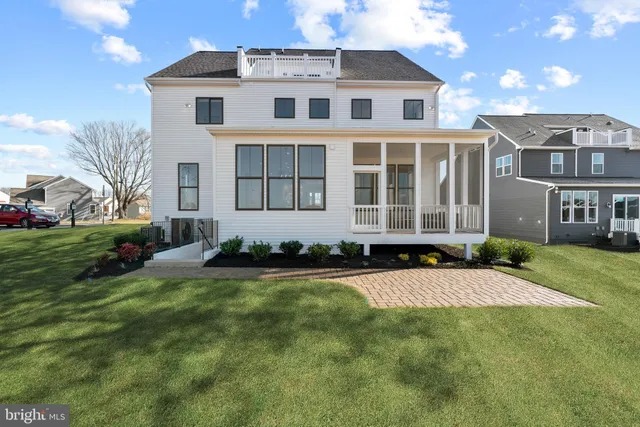 a front view of a house with a yard and trees