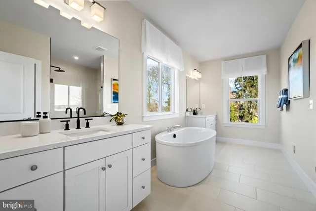 a bathroom with a tub a sink and mirror