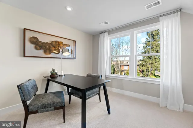 a view of a workspace with furniture and a window