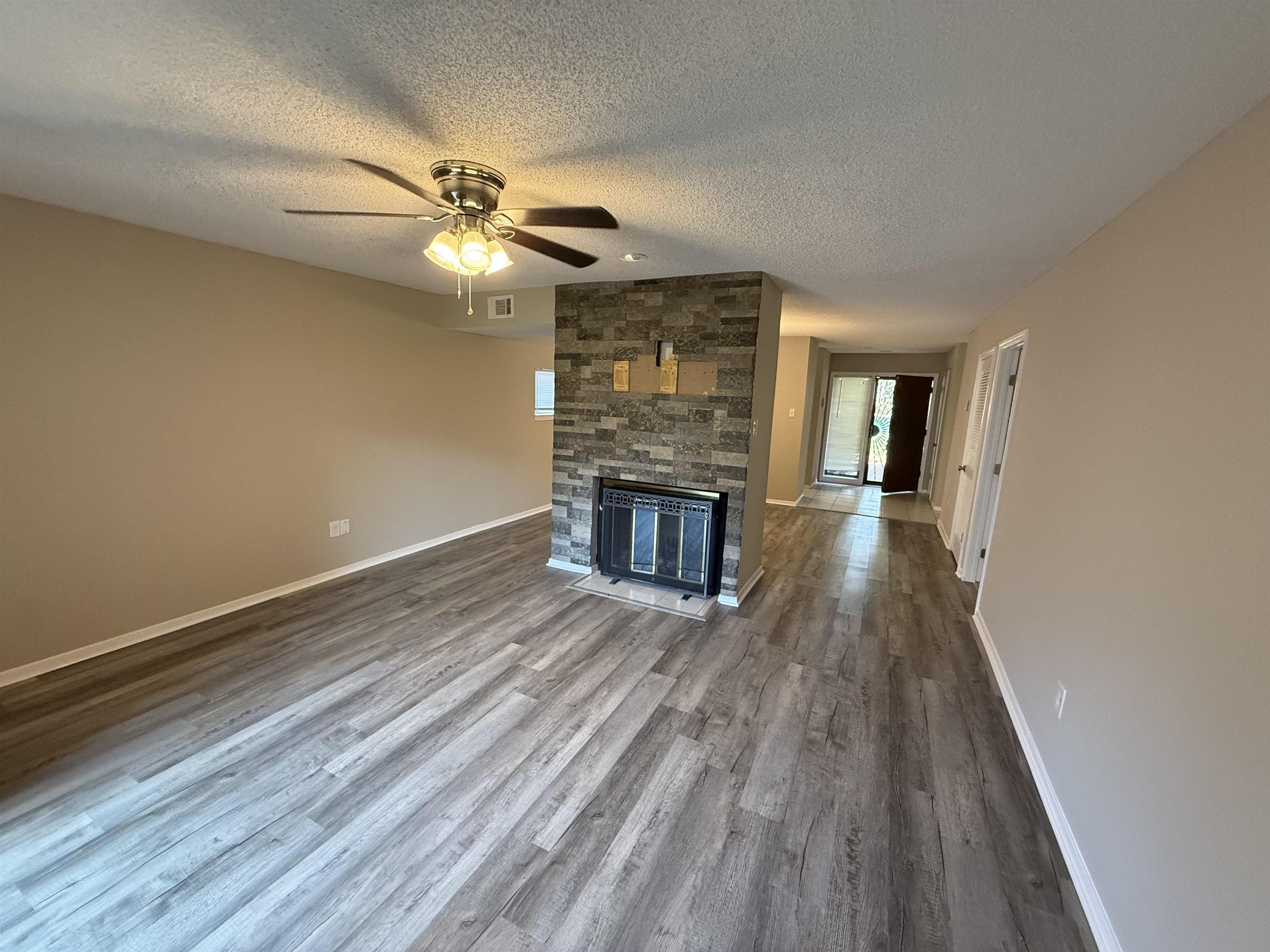 3084 Rising Sun Road, Unit 68 Lakeland, TN 38002 - Photo 10 of 13 Wood-finish flooring, stone-clad fireplace, and neutral wall tones