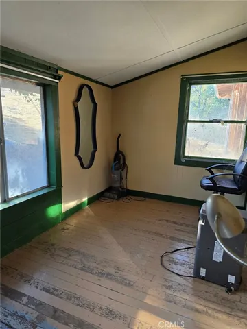 a room with wooden floor and windows