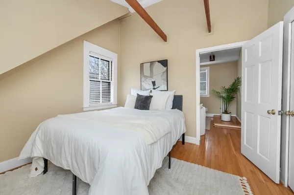 a bedroom with bed and wooden floor