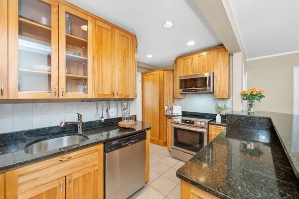 a kitchen with granite countertop stainless steel appliances a stove sink and microwave