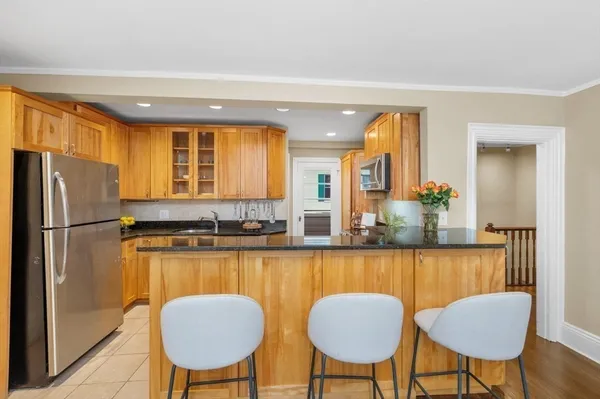 a kitchen with sink refrigerator dining table and chairs