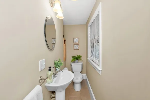 a bathroom with a sink toilet and a mirror