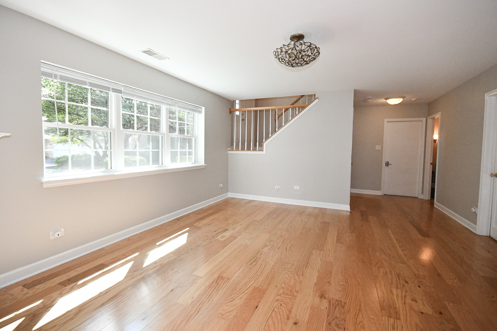 960 Elderberry Circle, Unit 108 Naperville, IL 60563 - Photo 16 of 32 a view of an empty room with wooden floor and a window