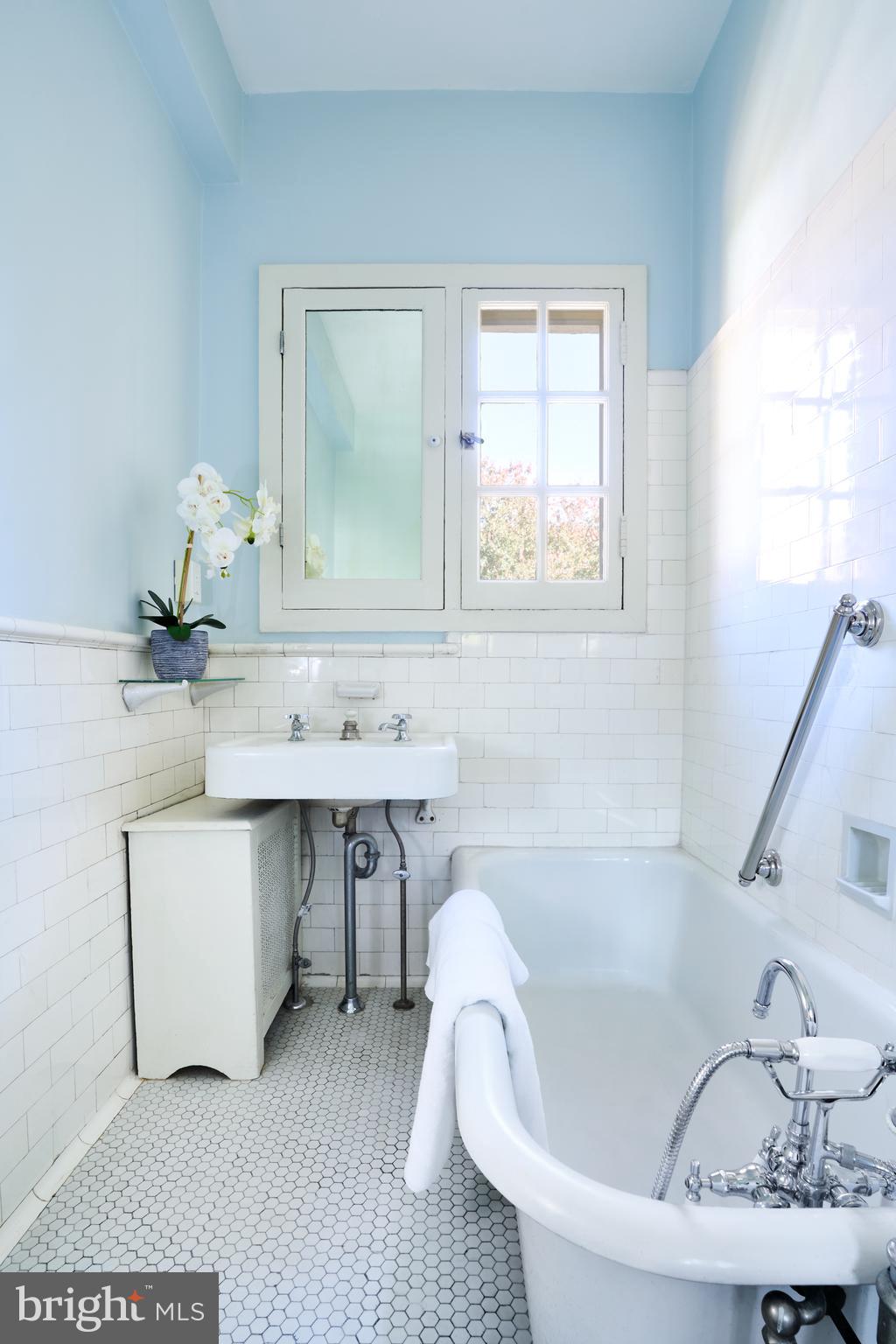 221 Stony Run Lane, Unit J2 Baltimore, MD 21210 - Photo 26 of 31 a bathroom with a tub sink and mirror