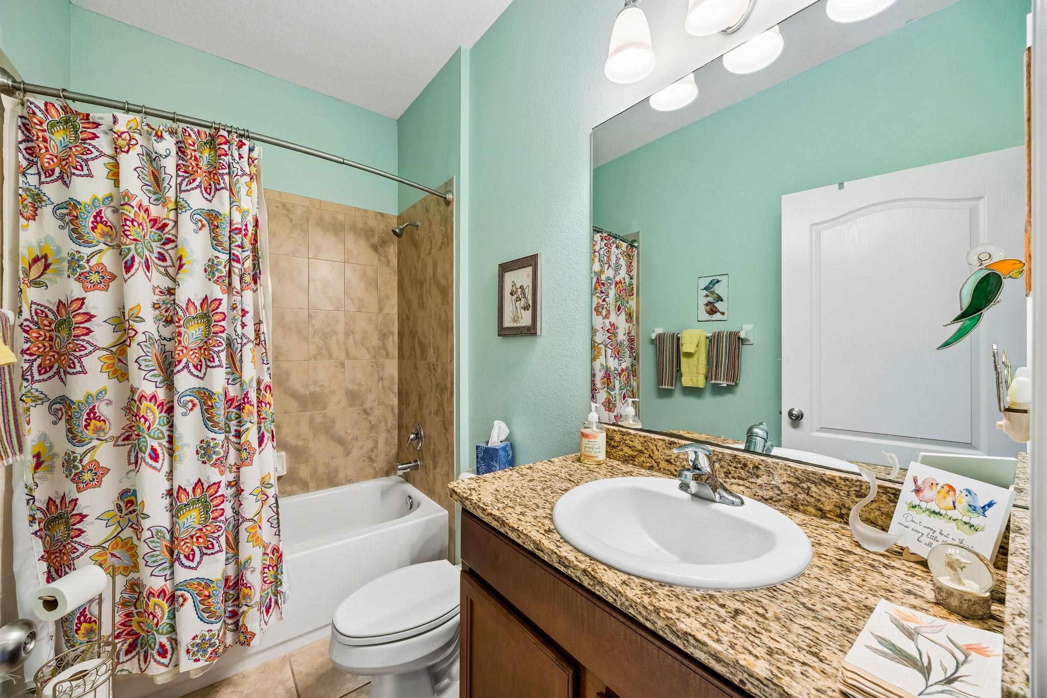 133 South Twin Maple Road St. Augustine, FL 32084 - Photo 21 of 34 Bathroom featuring vanity, shower / bathtub combination with curtain, light tile patterned flooring, and a textured wall