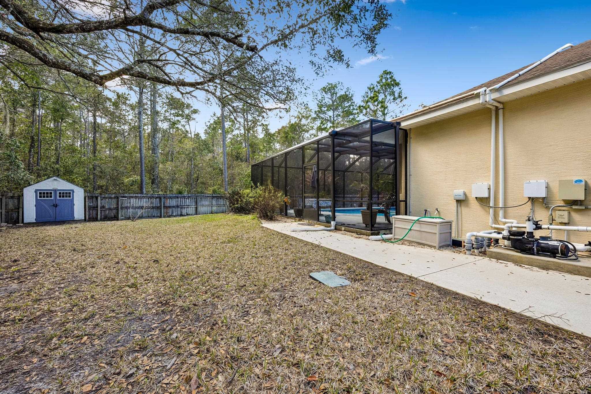 133 South Twin Maple Road St. Augustine, FL 32084 - Photo 28 of 34 Fenced backyard featuring a sunroom, glass enclosure, a storage shed, an outdoor pool, and a patio