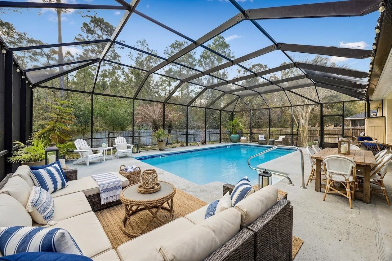 133 South Twin Maple Road St. Augustine, FL 32084 - Photo 3 of 34 View of pool featuring a fenced backyard, a sunroom, an outdoor living / dining area, patio surround, and glass enclosure
