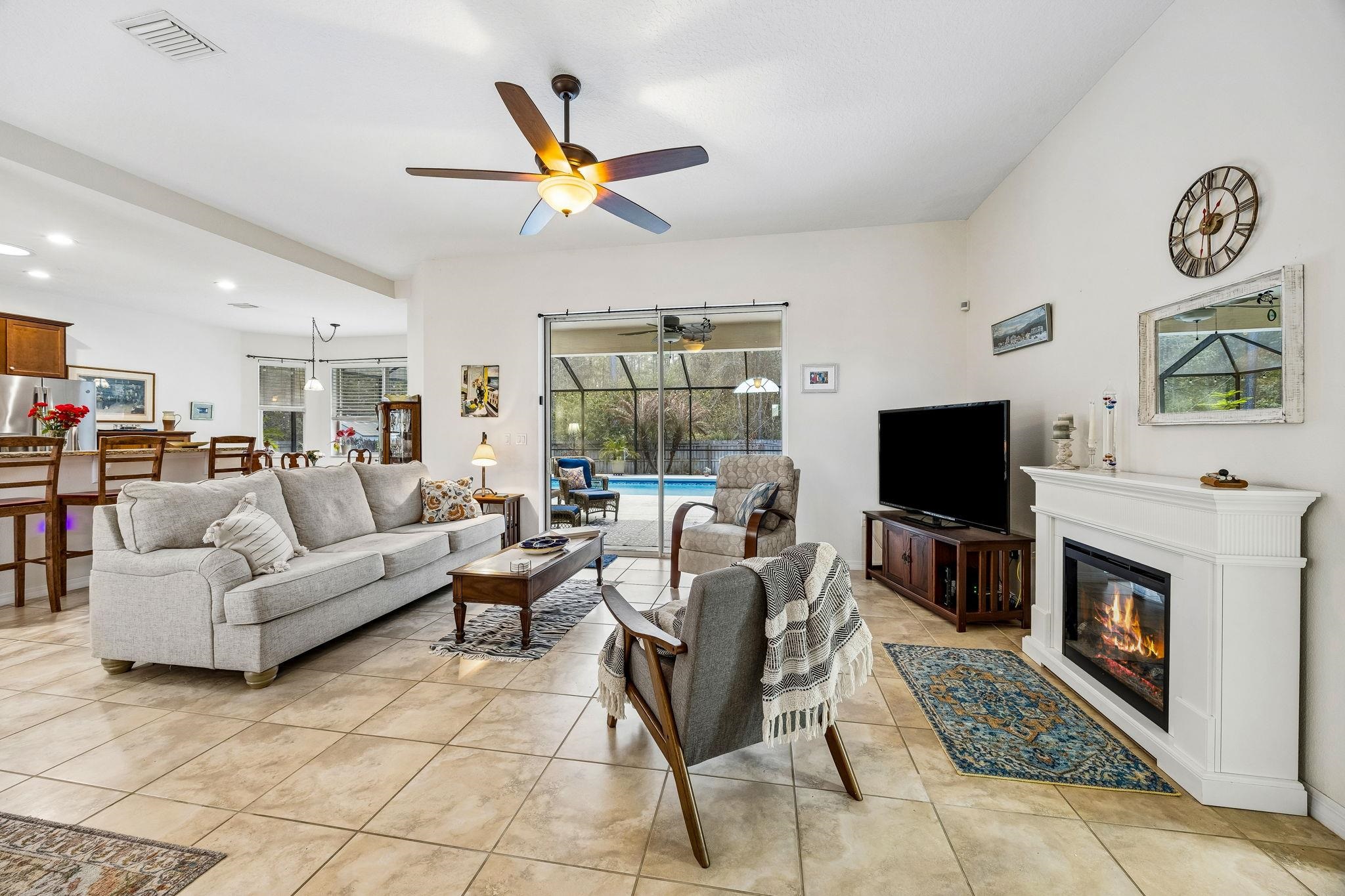 133 South Twin Maple Road St. Augustine, FL 32084 - Photo 7 of 34 Living area with a sunroom, ceiling fan, a glass covered fireplace, recessed lighting, and light tile patterned floors