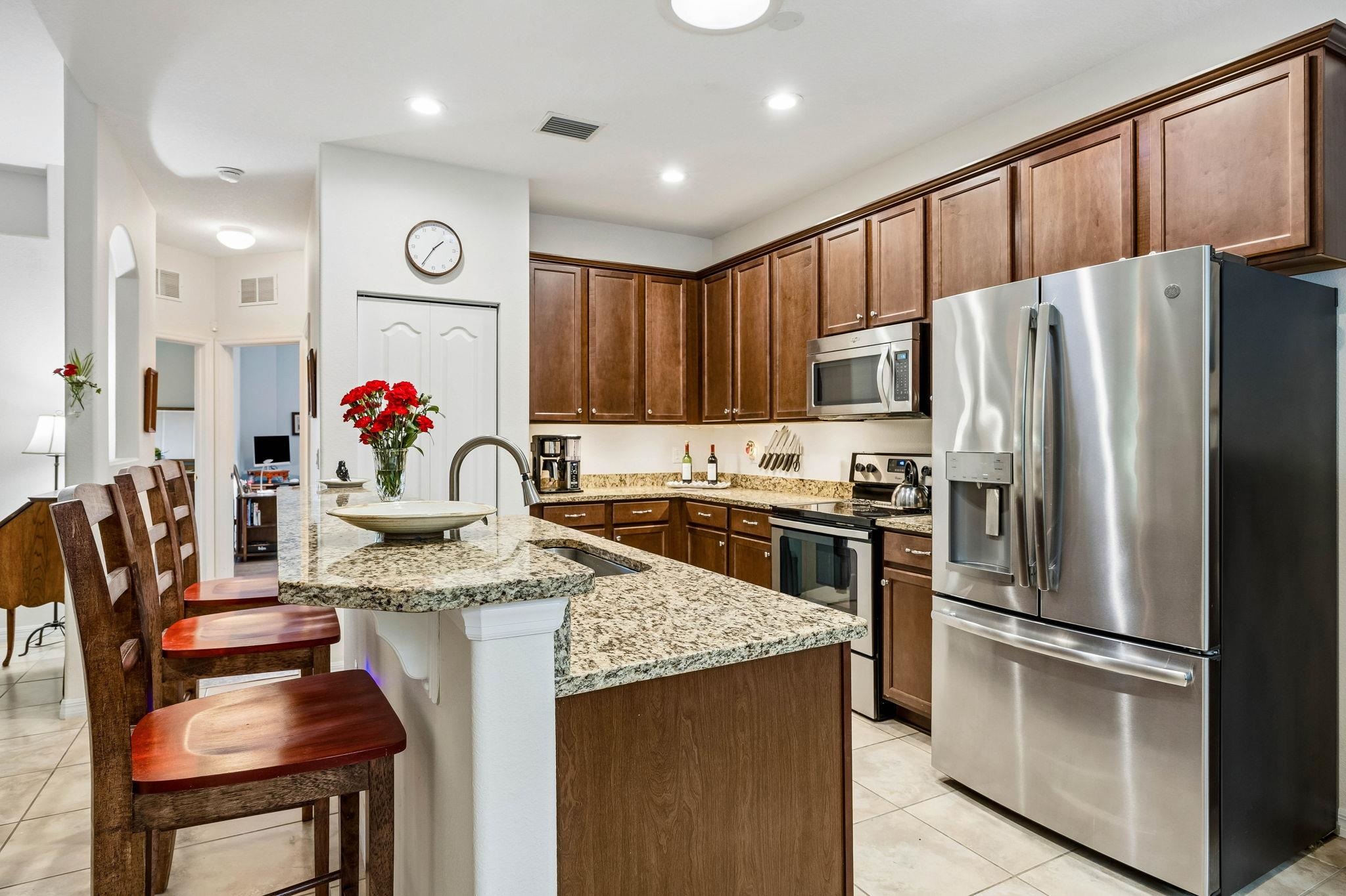 133 South Twin Maple Road St. Augustine, FL 32084 - Photo 9 of 34 Kitchen with stainless steel appliances, light stone countertops, a kitchen breakfast bar, light tile patterned floors, and recessed lighting