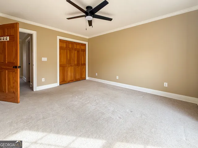 an empty room with closet and windows