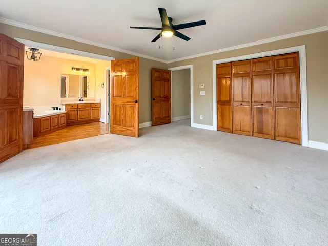 a view of a livingroom with an entryway and a ceiling fan